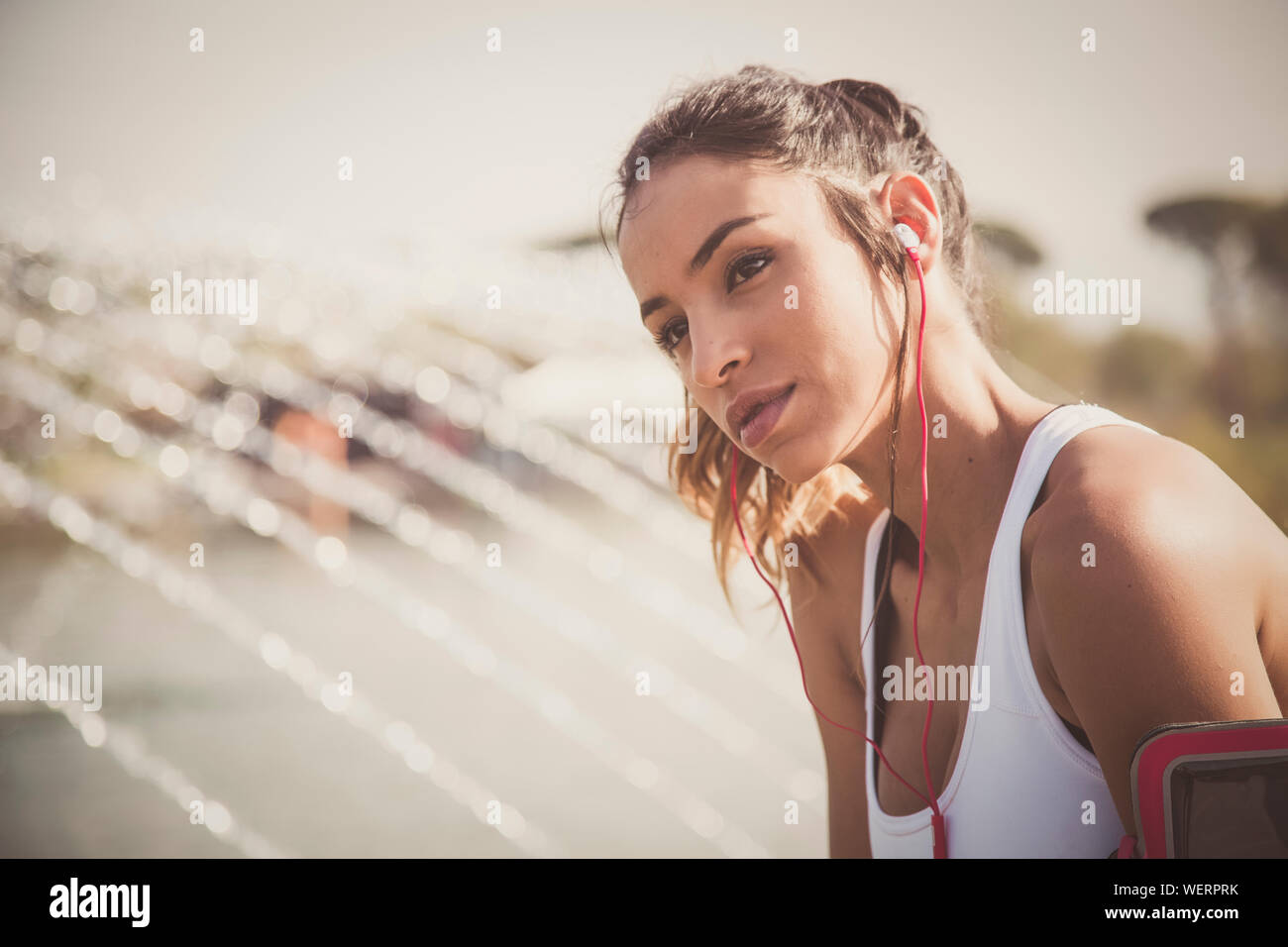 Portrait Of Young Woman In Sports Clothing By Fountain Stock Photo