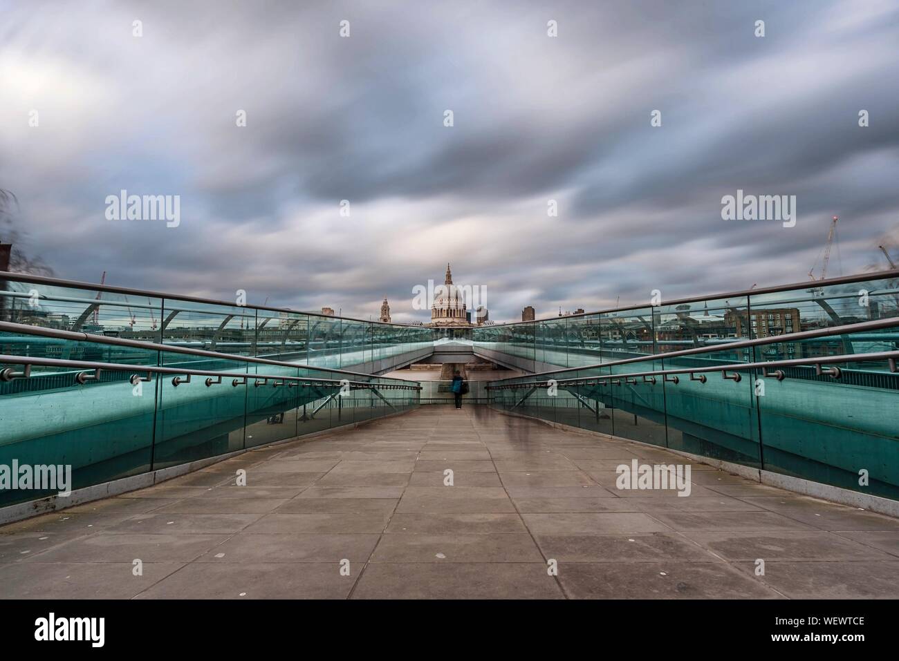 Diminishing View Of London Millennium Footbridge Against Cloudy Sky Stock Photo