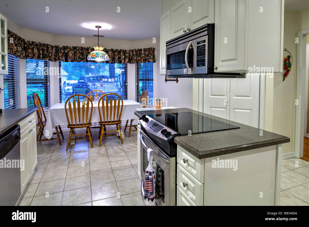 White outdated kitchen and dining area with island Stock Photo Alamy