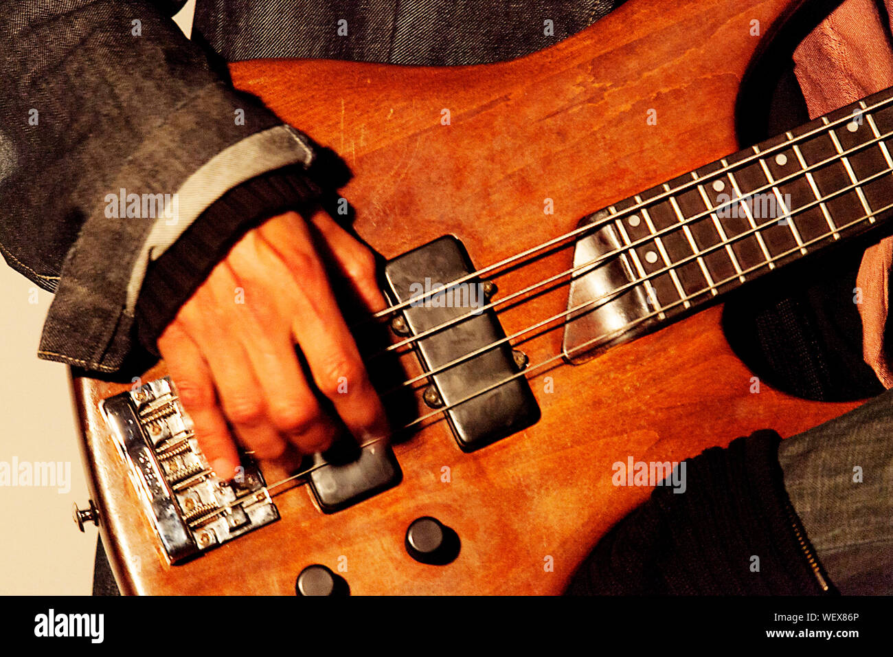 Midsection Of Musician Playing Bass Guitar Stock Photo