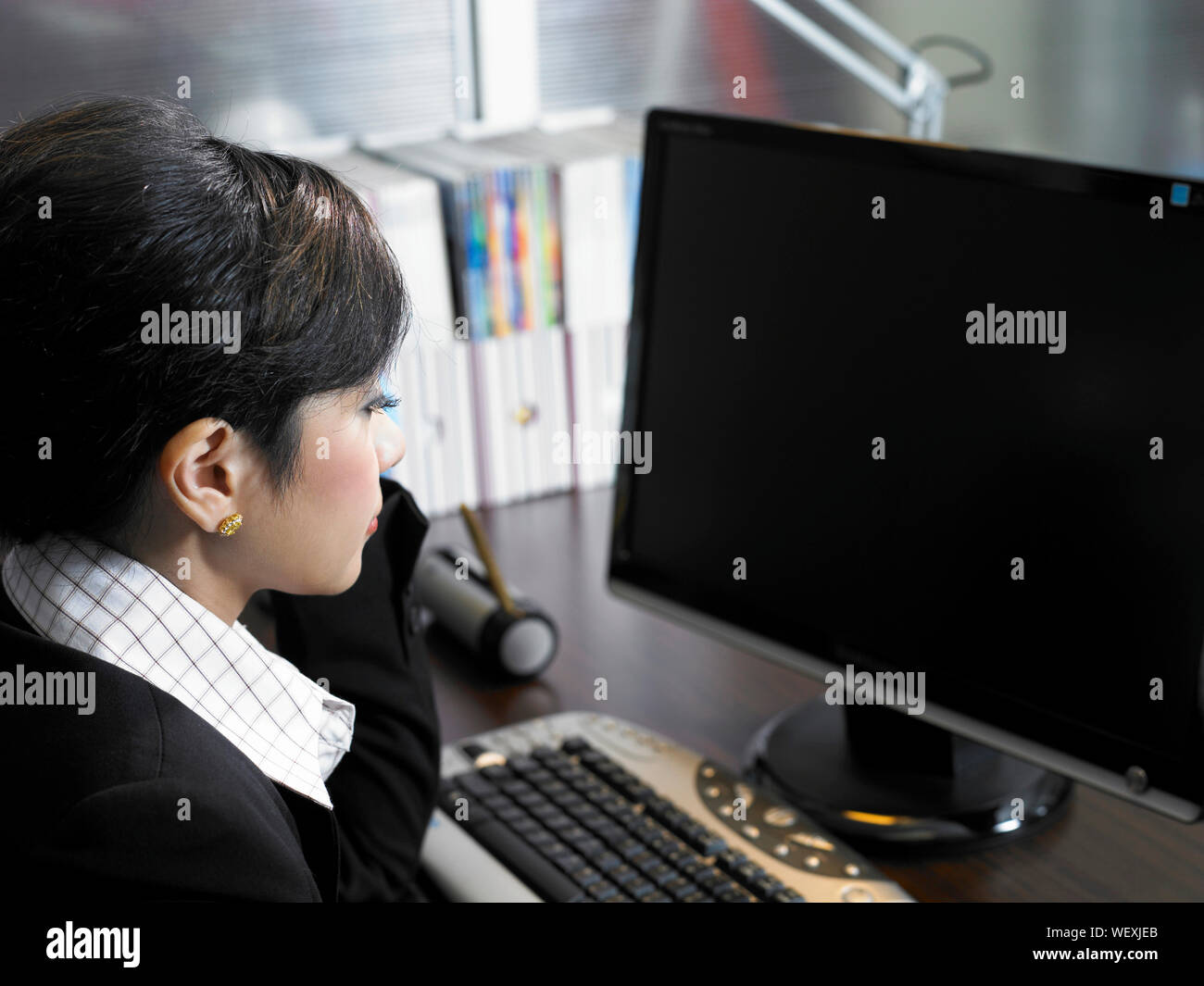 Young Businesswoman Looking Into Computer Screen At Office Stock Photo