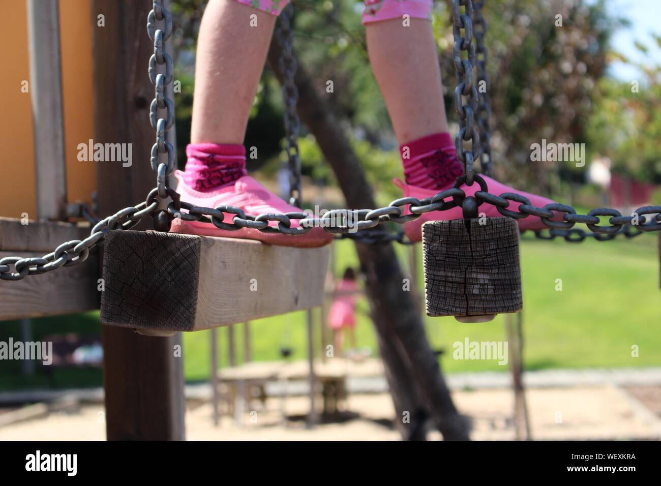 Low Section Of Girl Walking On Balance Beam At Playground Stock Photo