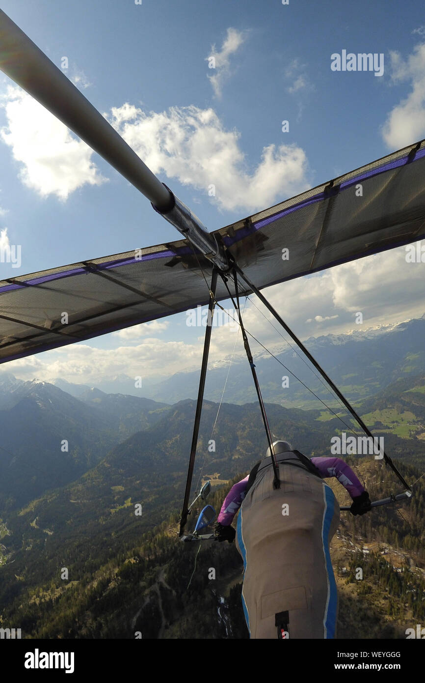 Hang glider pilot fly over mountain terrain in Greifenburg, Austria. Extreme airborne sports. Stock Photo