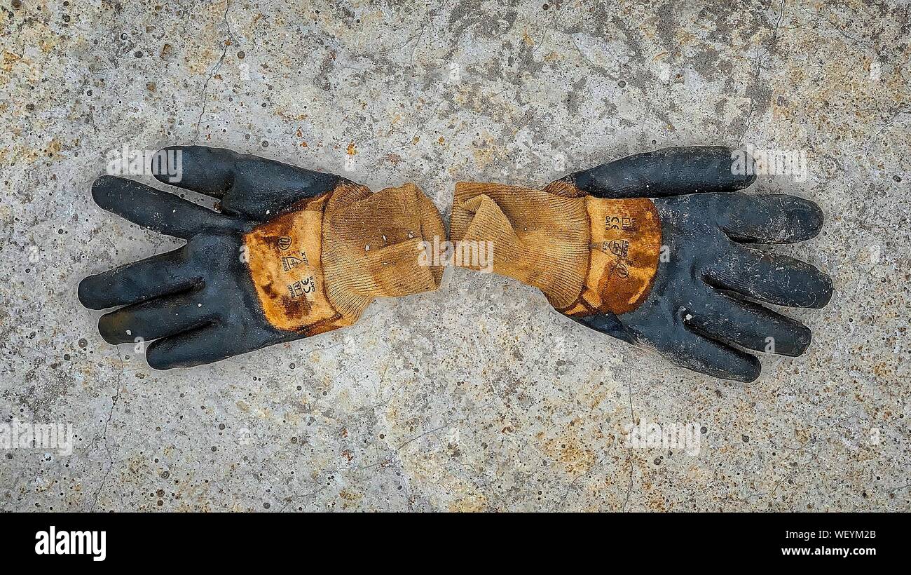 A pair of old work gloves over a reinforced concrete slab, at construction site Stock Photo