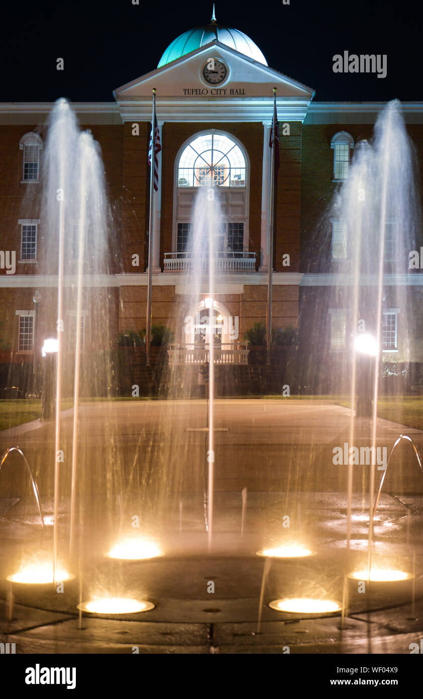 A night time view of Tupelo City Hall Building with water spout
