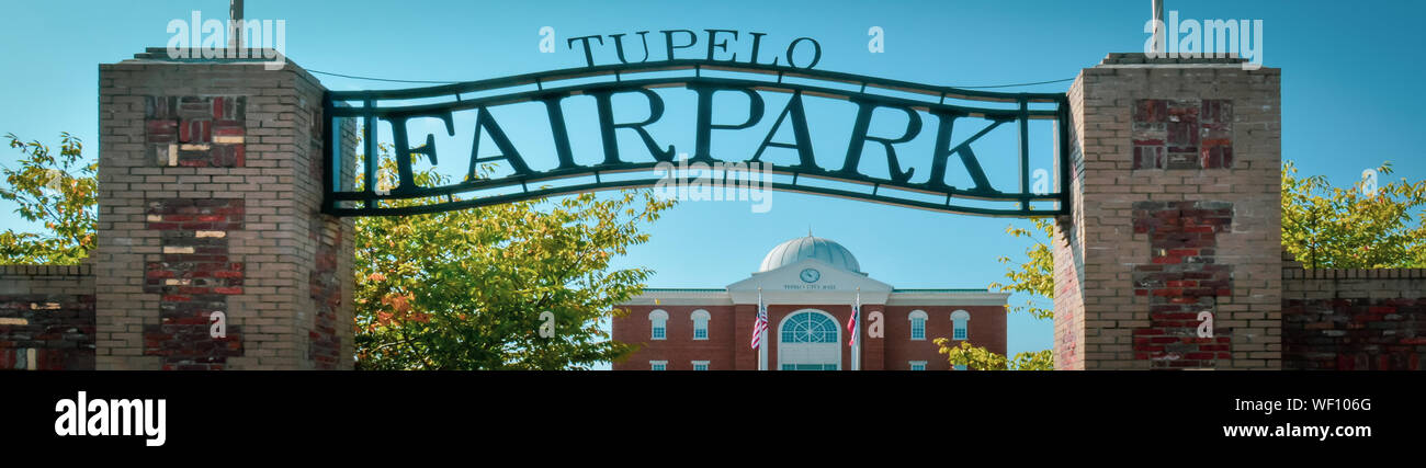 A panoramic view of the overhead metal sign for Tupelo Fair Park in front of the Tupelo City hall building, Elvis Presley preformed his 1956 homecomin Stock Photo