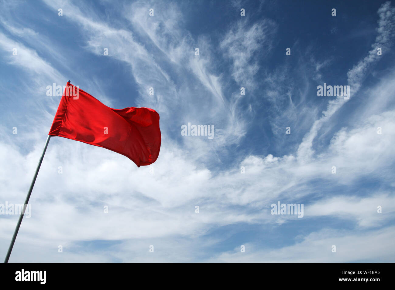 Low Angle View Of Red Flag Against Sky Stock Photo