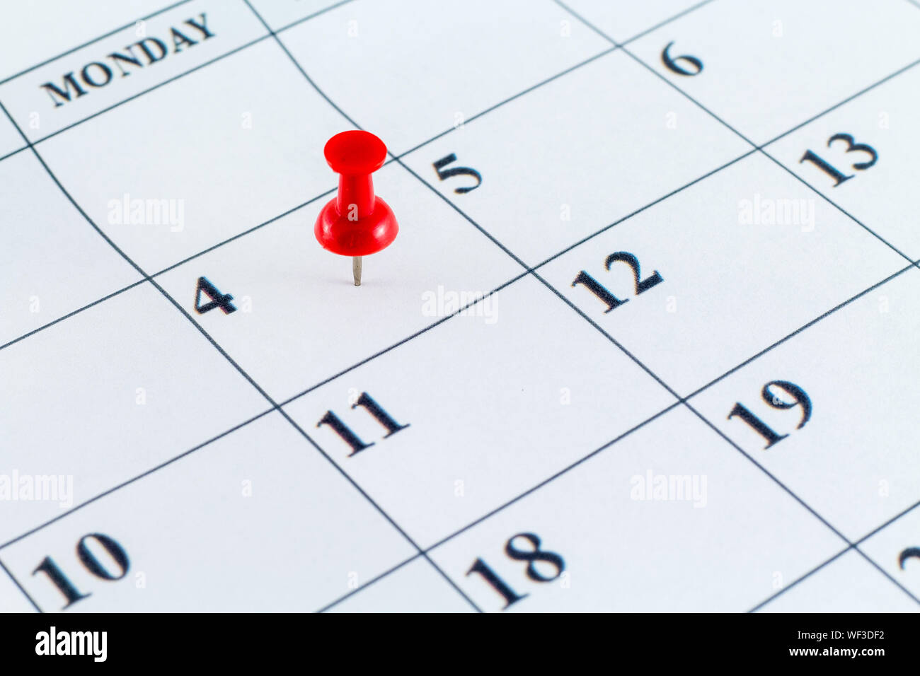 Close-up Of Thumbtack On Calendar Date Stock Photo