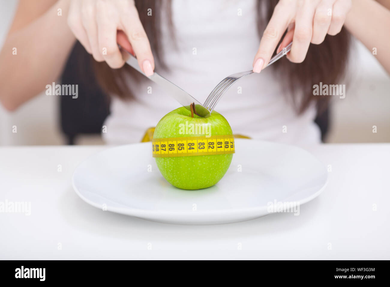 Diet. Apple and centimeter on the plate. Fitness healthy eating Stock Photo