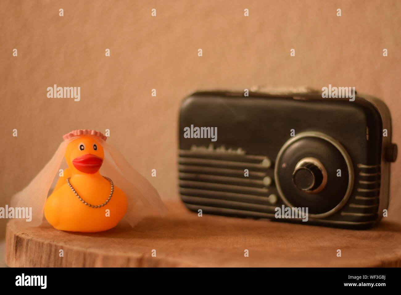 Close-up Of Rubber Duck With Radio On Wooden Table Against Wall Stock Photo  - Alamy