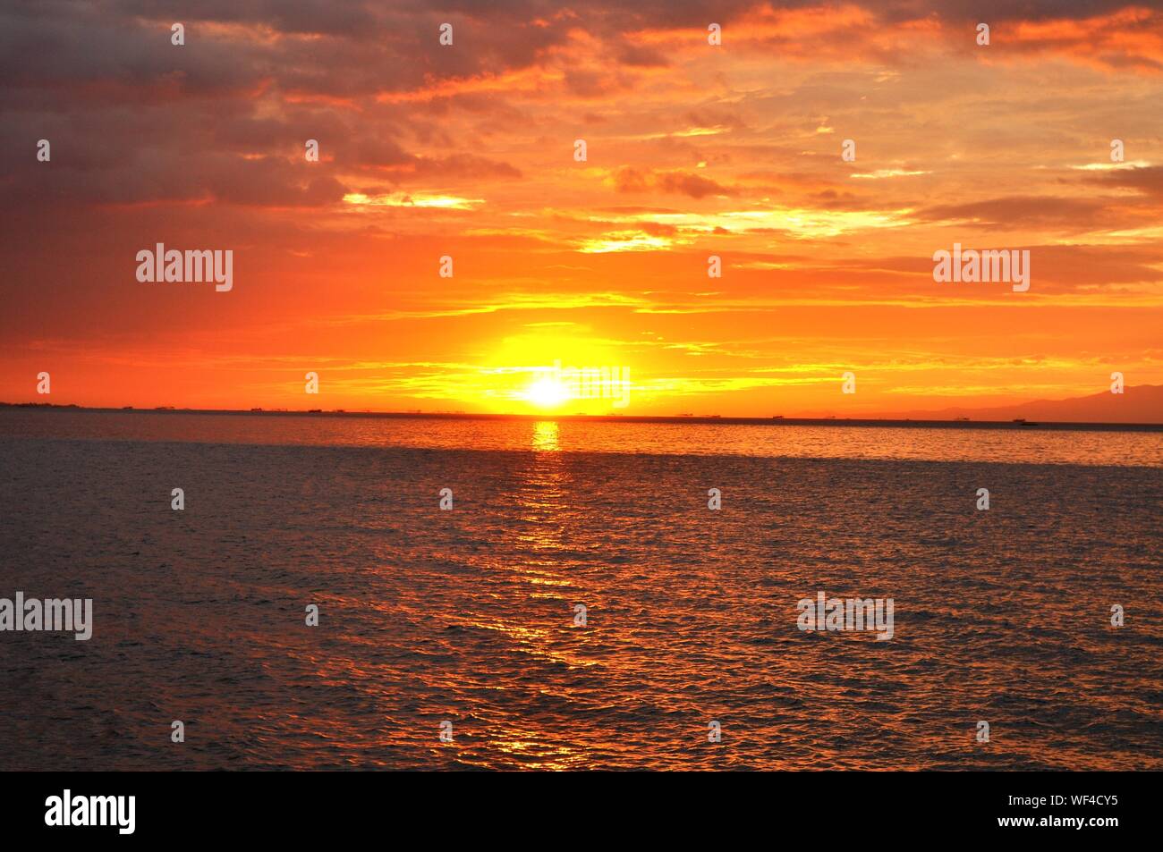 Idyllic Shot Of Manila Bay Against Orange Sunset Sky Stock Photo