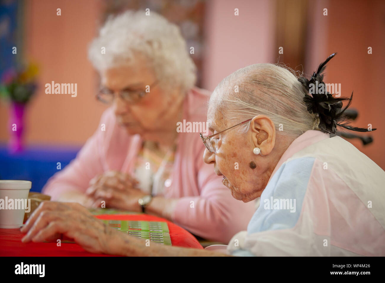 2 senior women sit playng cards at a senior center Stock Photo