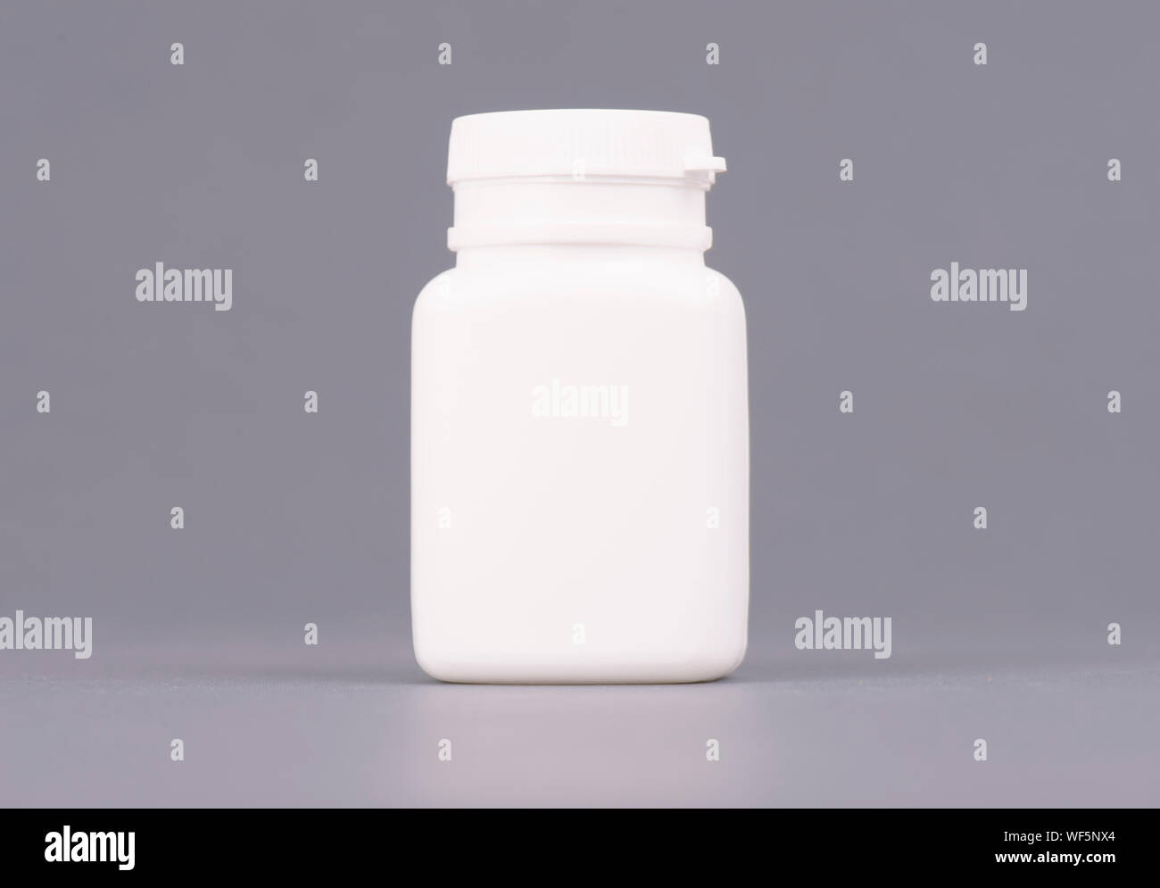 Blank big size medicine white plastic packaging bottles for cosmetics, vitamins, pills or capsules. Packaging on gray background Stock Photo