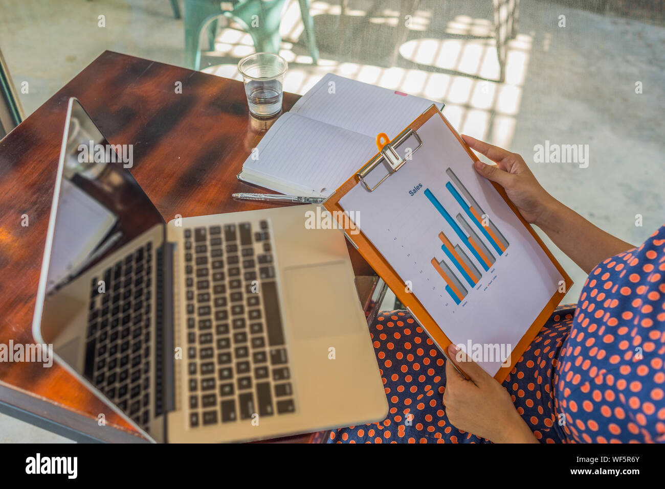 Businesswoman holding and analyzing sales statistics data document  Stock Photo
