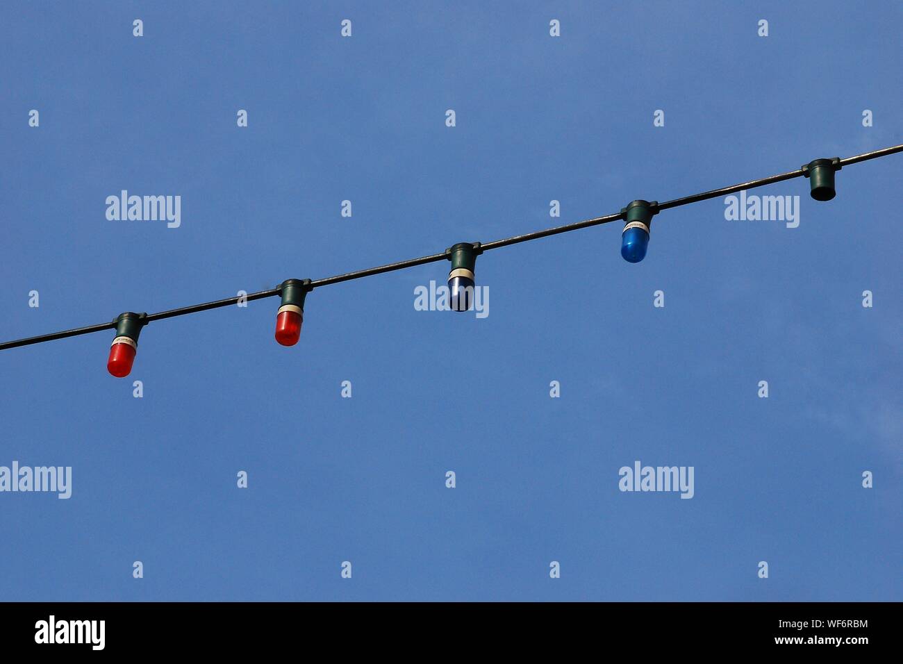 Low Angle View Of Lighting Equipment Against Blue Sky Stock Photo