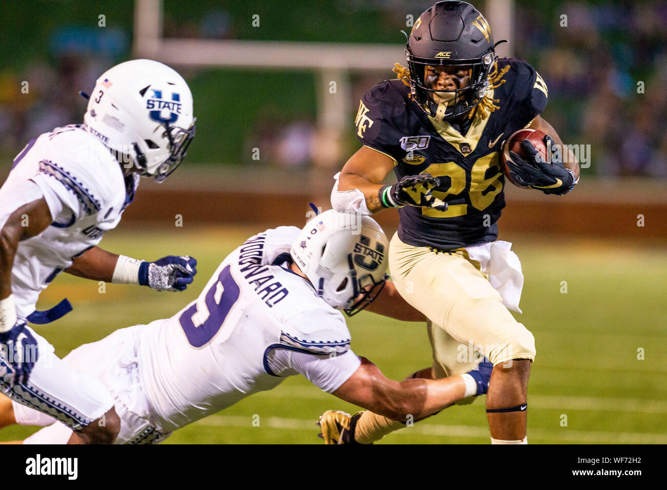 August 30, 2019: Wake Forest Demon Deacons running back Christian Beal-Smith (26) breaks free from Utah State Aggies linebacker David Woodward (9) for a touchdown in the third quarter of the NCAA matchup at BB&T Field in Winston-Salem, NC. (Scott Kinser/Cal Sport Media) Stock Photo