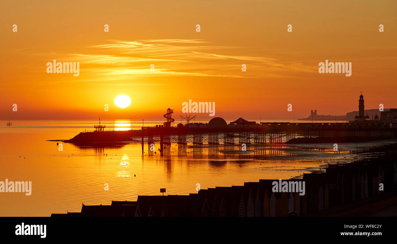 Herne Bay, Kent, UK. 31st August 2019: UK weather. A glorious sunrise at Herne Bay pier in Kent with the towns clock tower, believed to be the worlds first free standing clock tower ever built on the right and Reculver towers on the horizon. Forecasts for September include the return of hot weather and an Indian summer for parts of the country. Credit: Alan Payton/Alamy Live News Stock Photo
