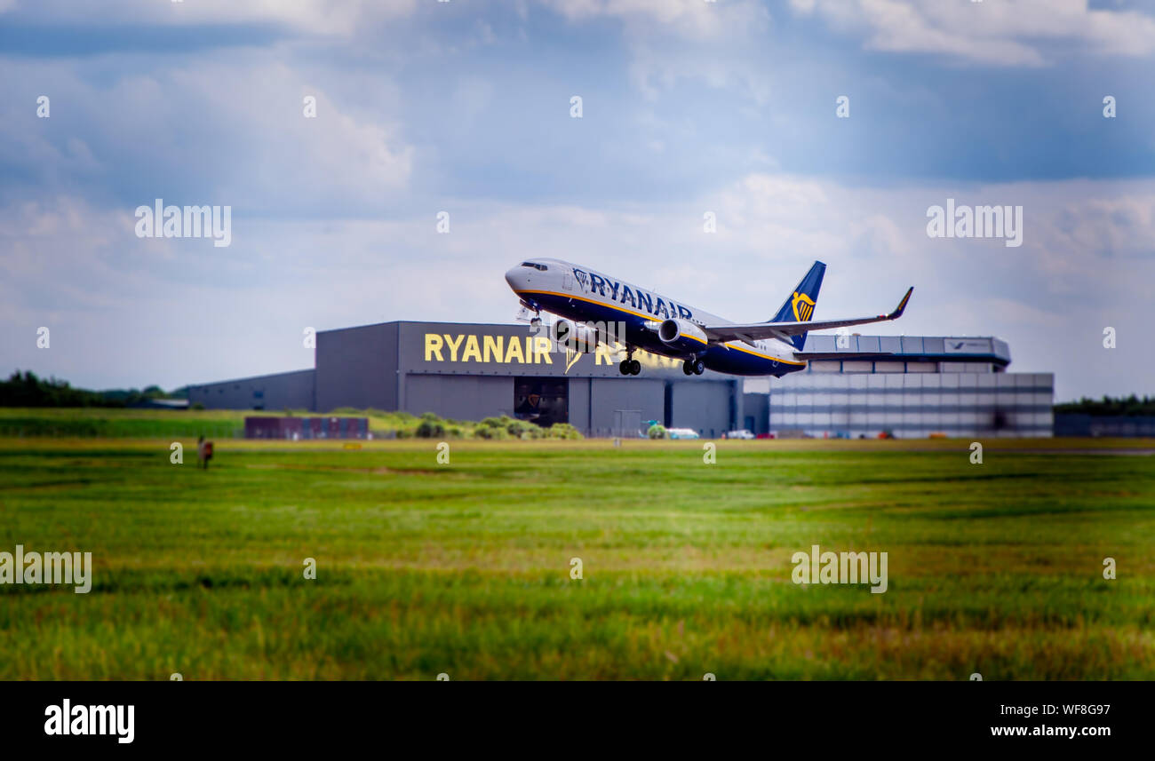 LONDON STANSTED AIRPORT, ESSEX / UK - CIRCA JULY, 2019: Ryanair Boeing 737 takes off with visible Ryanair hangar in background Stock Photo