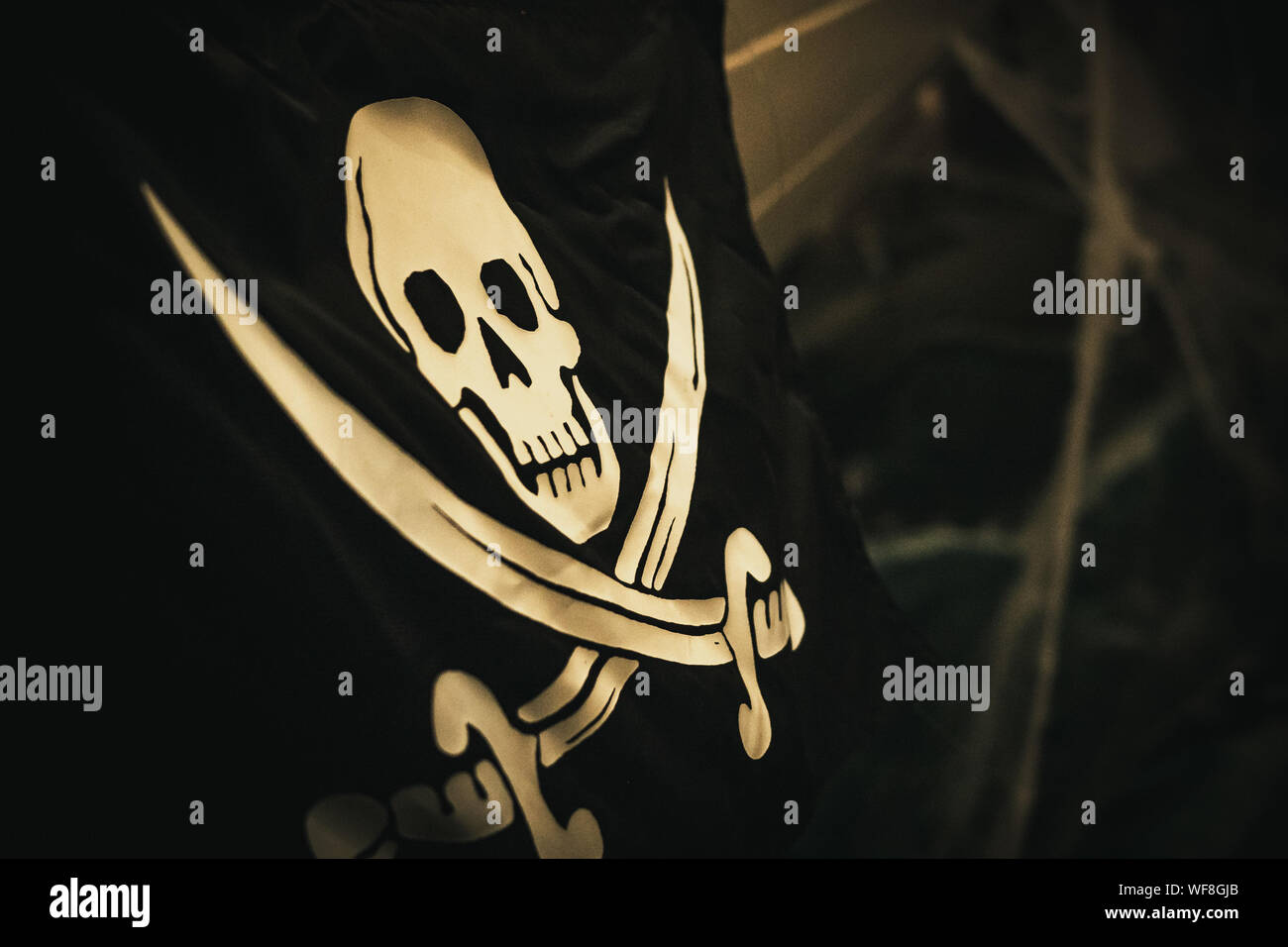 skull and crossbones flag waving in the air above a ship Stock Photo Alamy