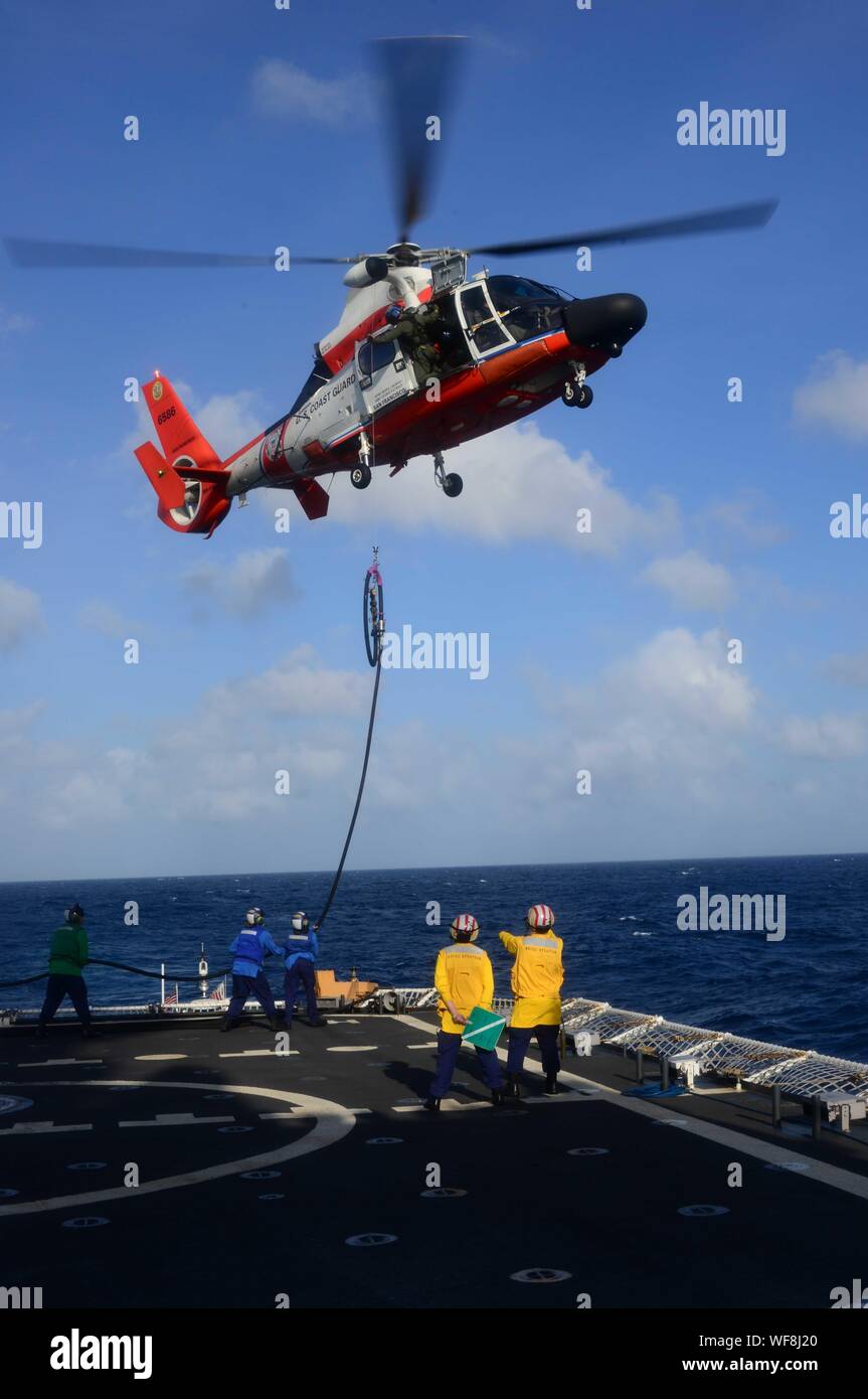 Crewmembers aboard the Coast Guard Cutter Stratton (WMSL 752) practice in-flight refueling with an MH-65 Dolphin helicopter Aug. 28, 2019, while the Stratton transits the Bay of Bengal. The operation was part of routine training and qualification experience for crewmembers of Stratton. (U.S. Coast Guard photo by Petty Officer 1st Class Levi Read) Stock Photo