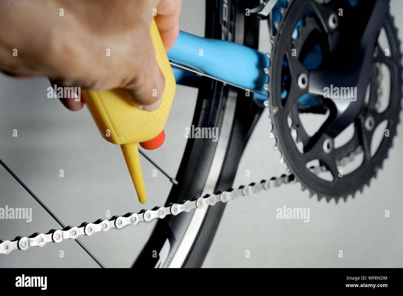 Mechanic oiling bicycle chain and gear with oil. Studio shot Stock Photo