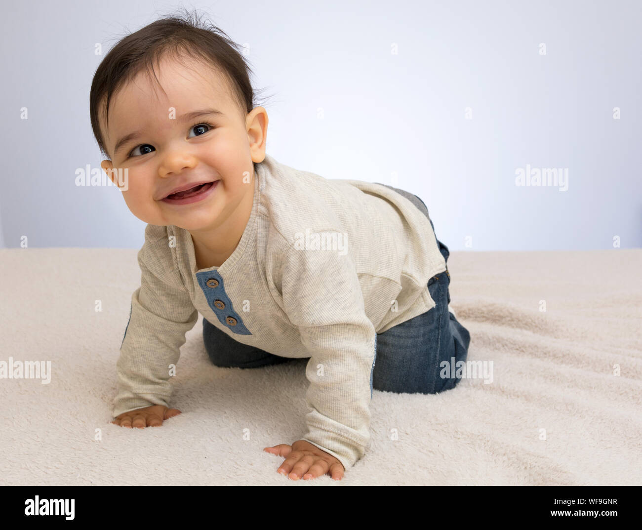 Cute Baby Boy On Bed Against Wall At Home Stock Photo Alamy
