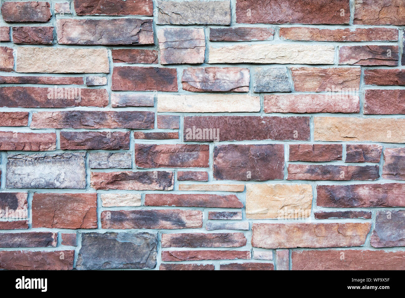 Block stone wall background in warm tones. Stock Photo