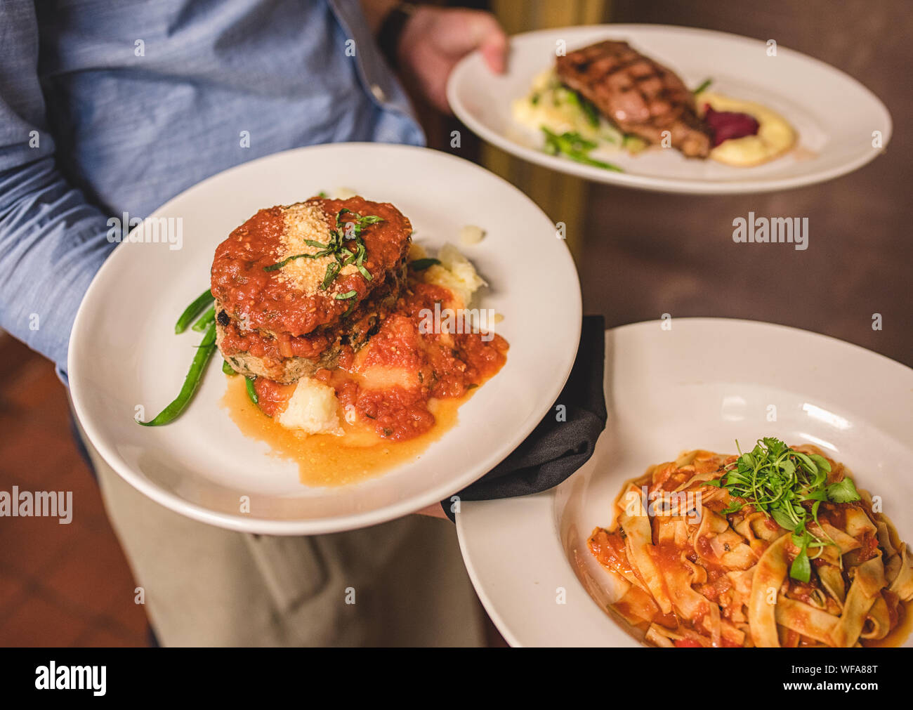 Waiter carrying plates hires stock photography and images Alamy