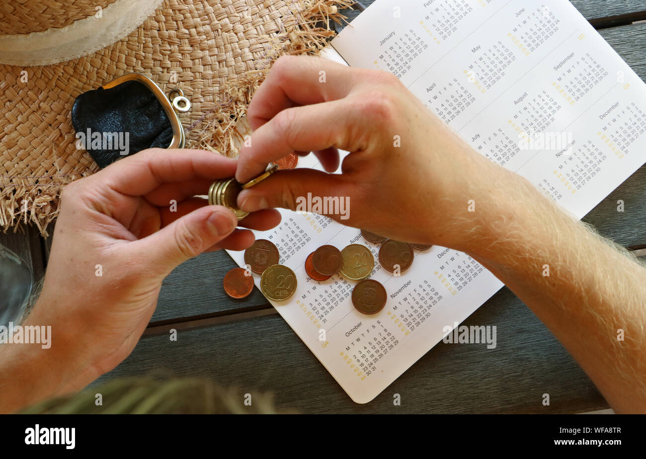 Cropped Hands Of Man Calculating Money On Diary Stock Photo
