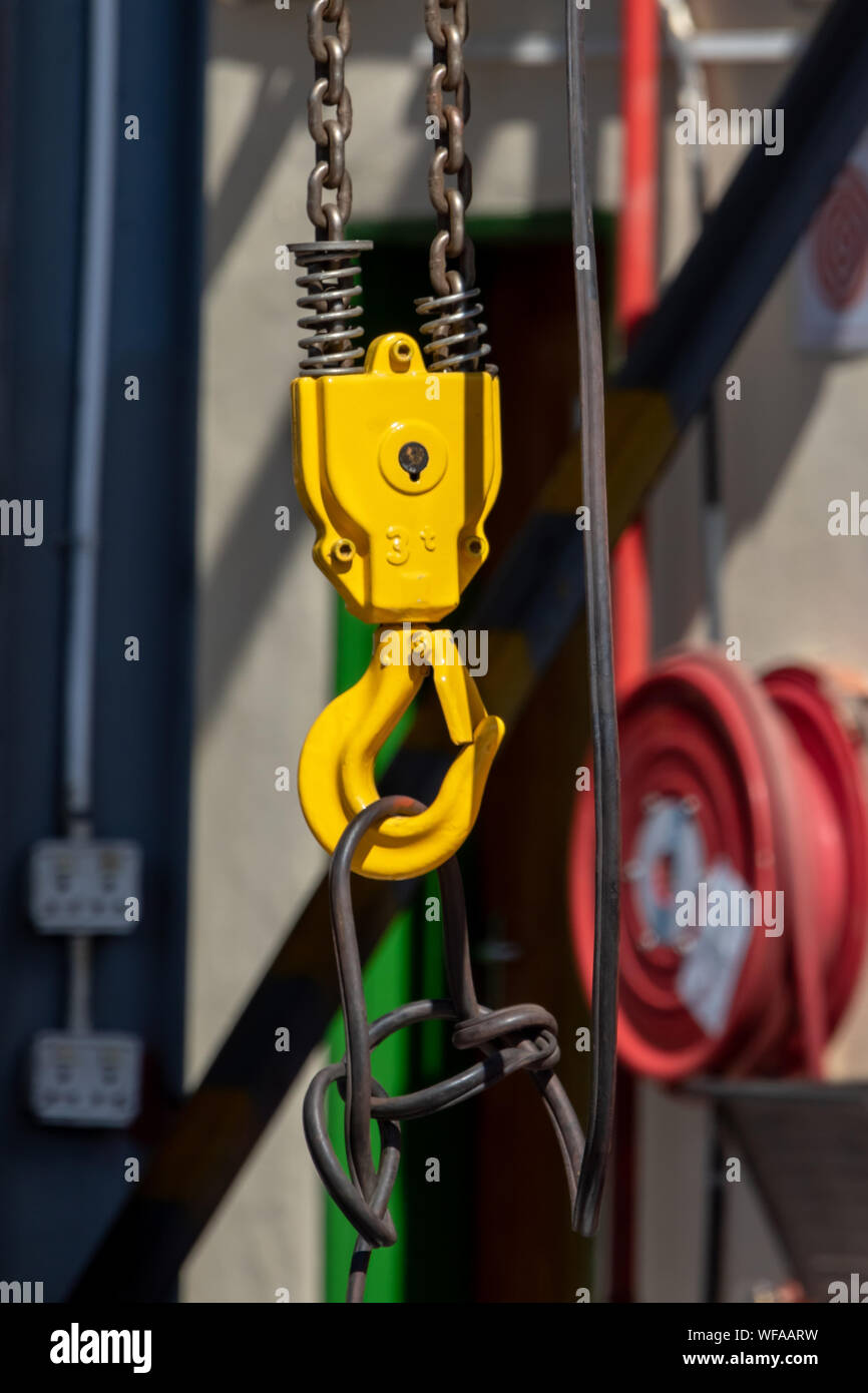 Yellow crane hook and a chain hoisting weight Stock Photo Alamy