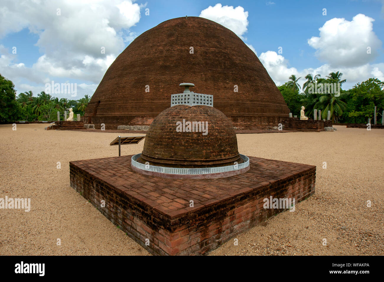A small stupa sitting adjacent to the  Buddhist red brick Sandagiri Stupa which is located at Tissamaharama in Sri Lanka. Stock Photo