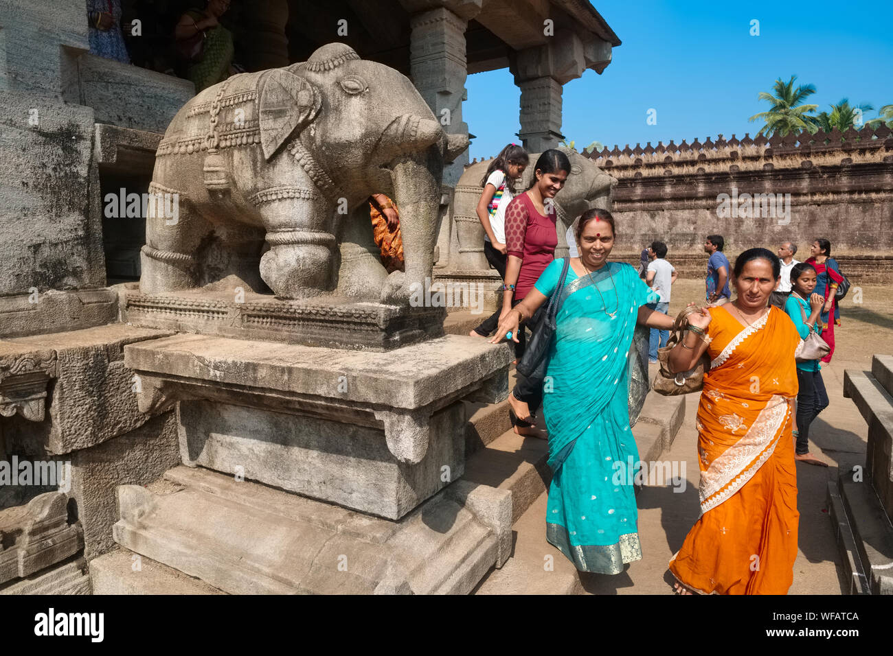 Visitors leaving the Thousand Pillar Temple (Saavira Kambada Basadi), a Jain temple in Moodabidri, Karnataka, India, passing elephant stone figures Stock Photo