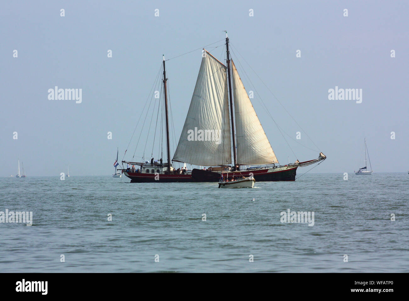 The beautiful scenery of traditional fisherman sailing ship when it is seen over the sea on Volendam waters in the summer. Stock Photo