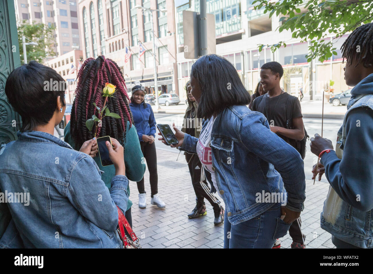 Teenage high school friends having fun in casual and relaxed manner on the street of downtown Cleveland, Ohio, USA. Stock Photo