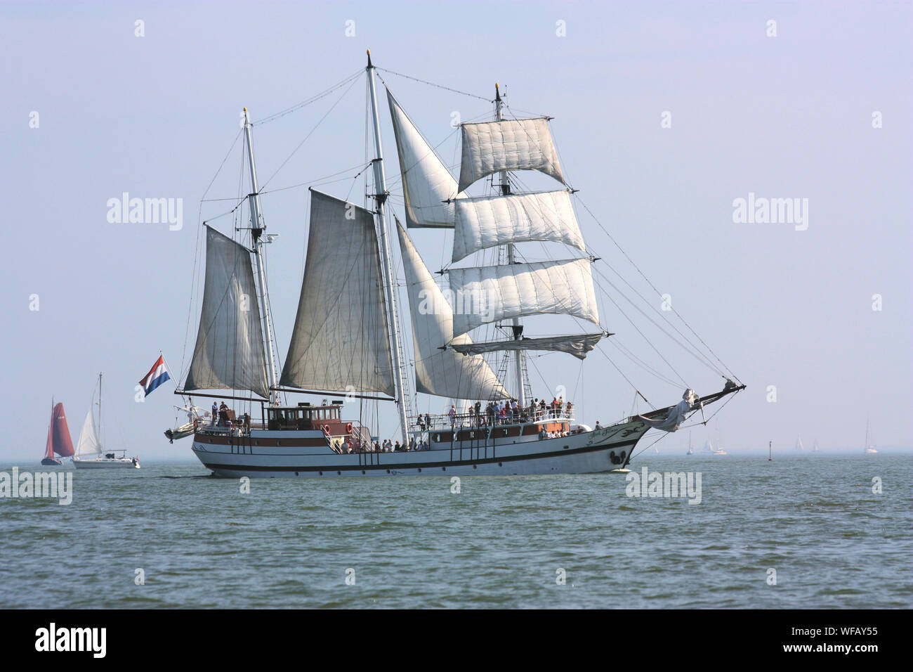 The beautiful scenery of traditional fisherman sailing ship when it is seen over the sea on Volendam waters in the summer. Stock Photo