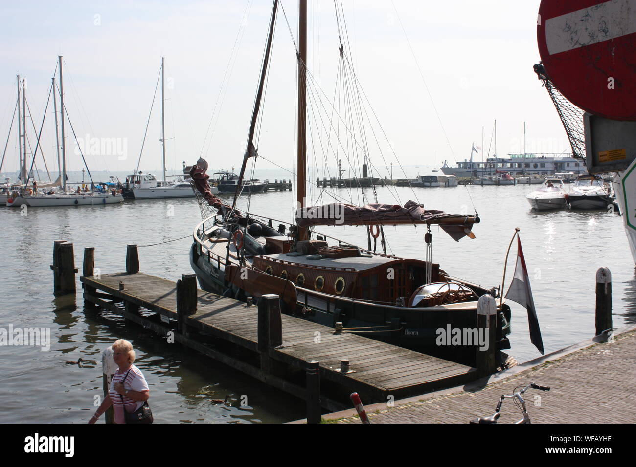 A traditional fishing boat is docking on the jetty in Volendam coast in Holland, Nederland, while the fishermen are preparing for the sailing. Stock Photo