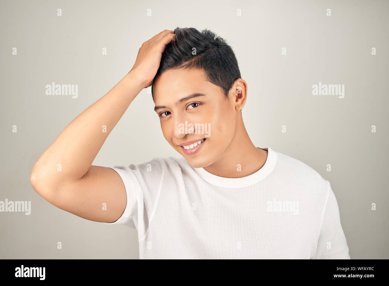 Portrait of happy healthy man combing his hair with fingers Stock Photo