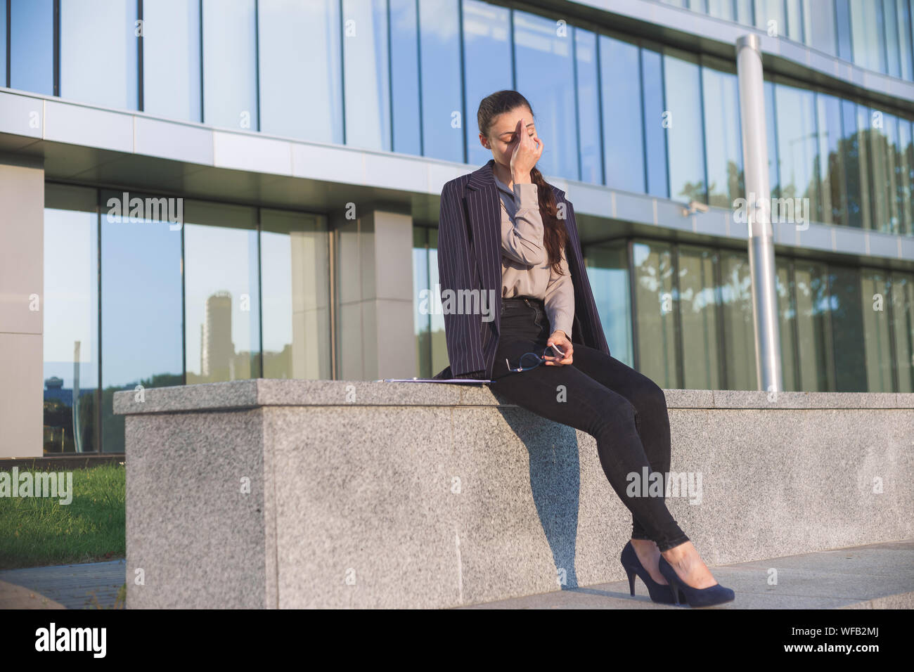 Young woman in suit suffer from stressful work. Stock Photo