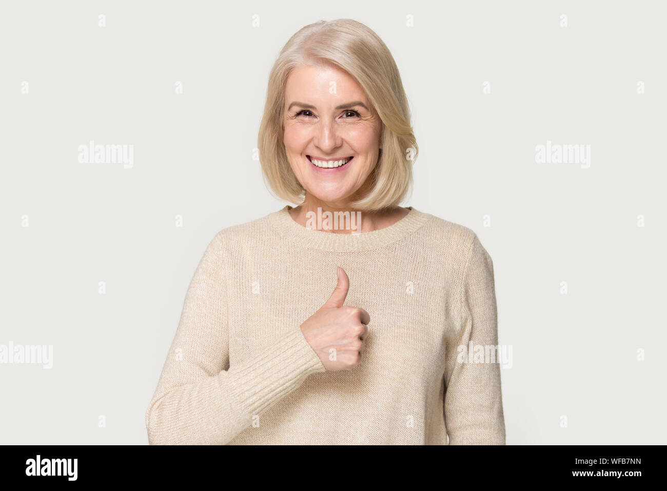 Happy mature woman show thumbs up recommending service Stock Photo