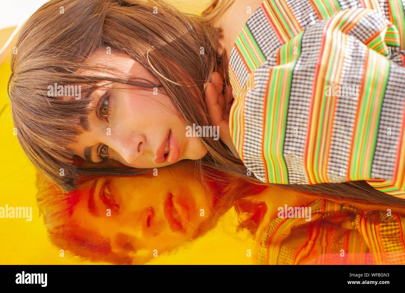 Portrait of a woman lying on holographic foil Stock Photo