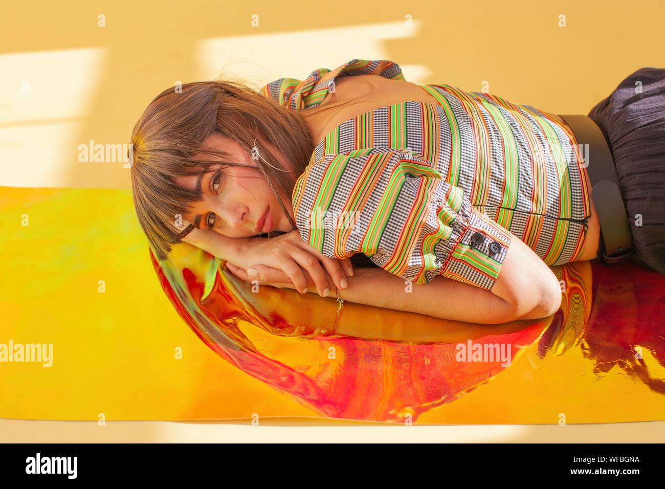 Portrait of a woman lying on holographic foil Stock Photo