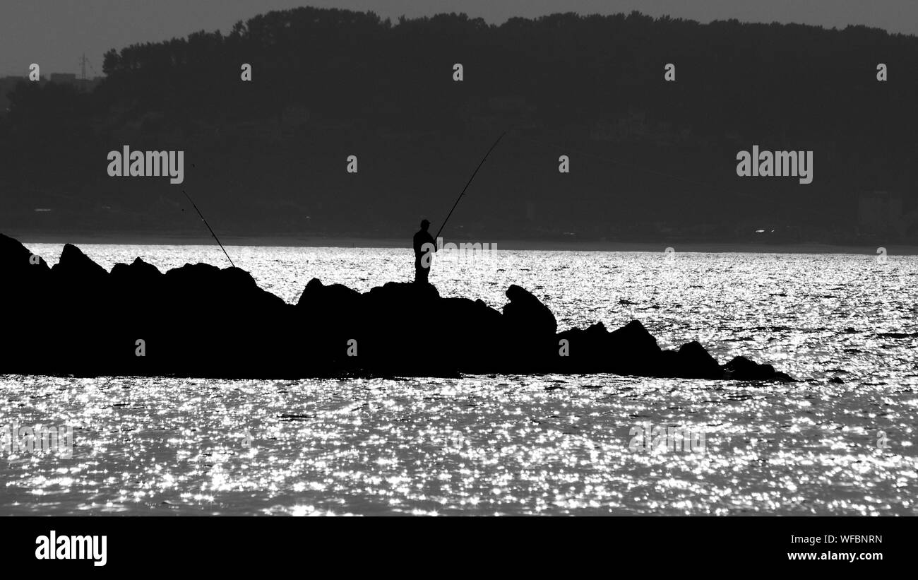 Silhouette of man fishing Black and White Stock Photos & Images - Alamy