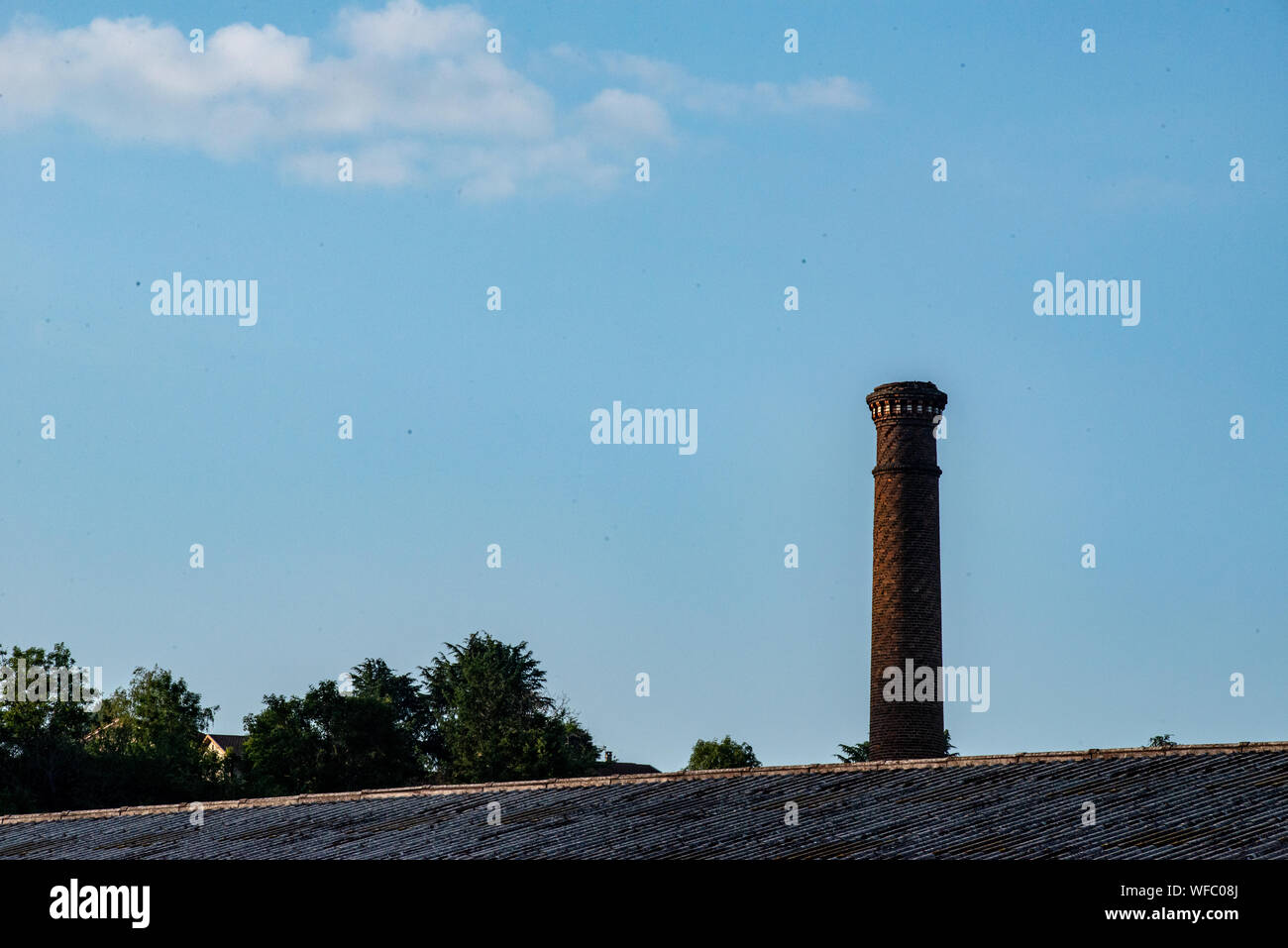 Red brick chimney against blue sky Stock Photo