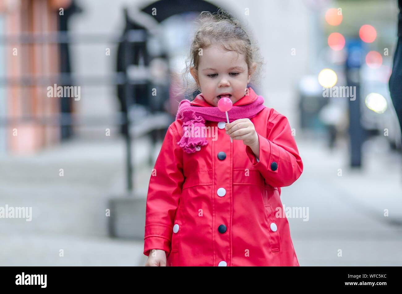 Girl In Pink Jacket Holding Lollipop Stock Photo - Alamy