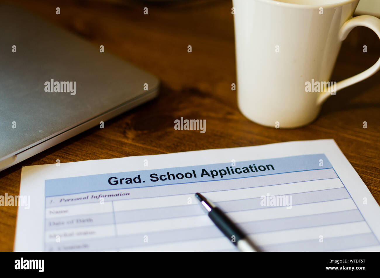 Close-up Of Application Form With Coffee Cup And Pen On Table Stock Photo