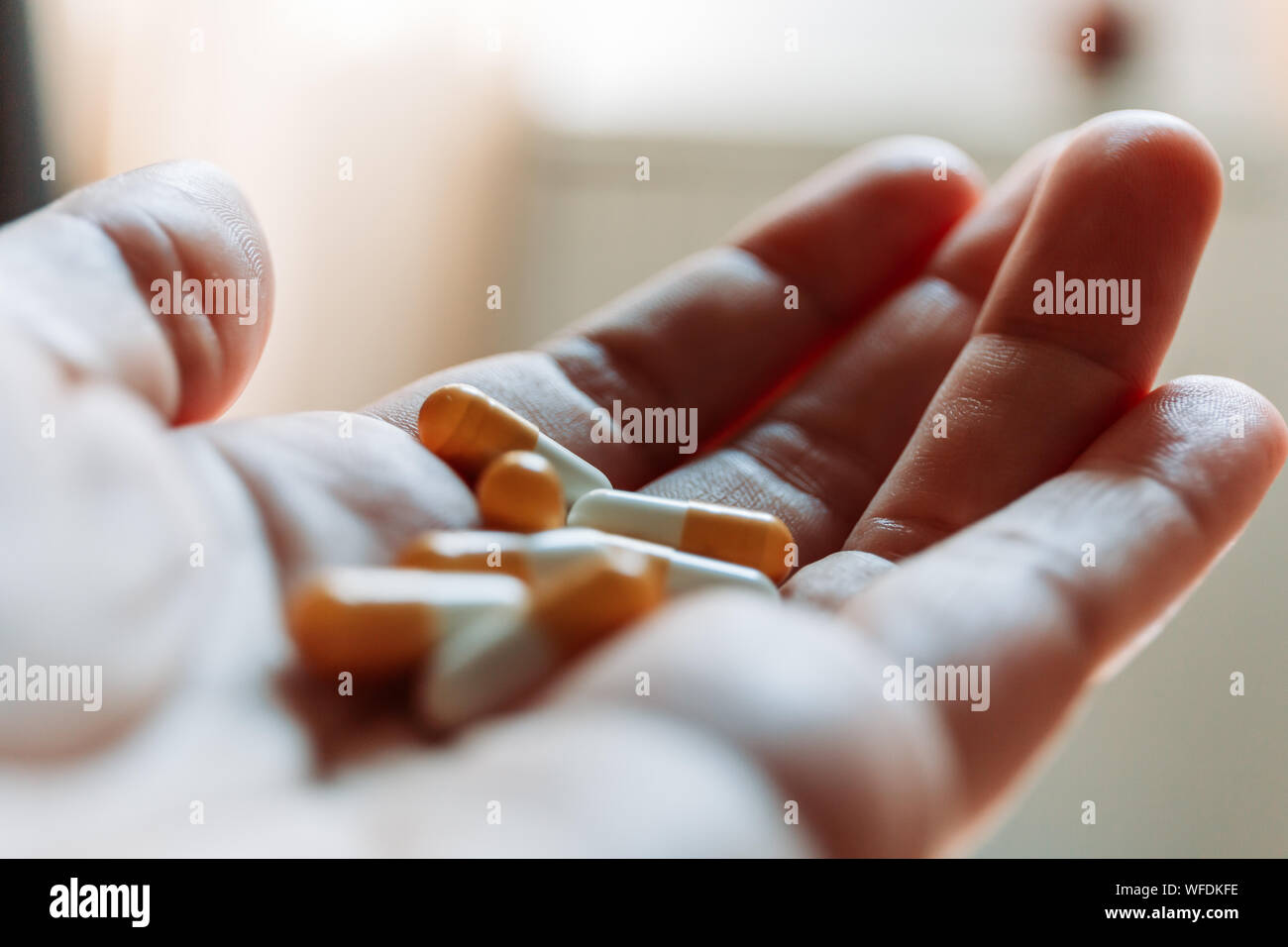 Close up hand of woman overdosing on medication. Close up of overdose pills in addict hand. Overdose concept. Stock Photo
