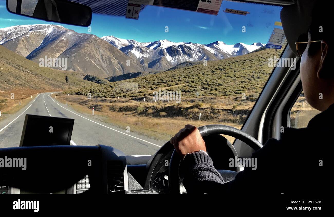 Midsection Of Man Driving Car Against Mountain Range Stock Photo
