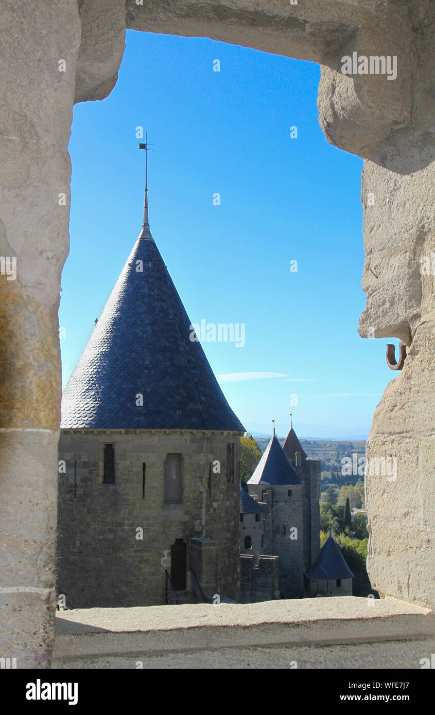 View through opening in rampart wall showing watchtowers and blue sky. Carcassonne medieval city. France, Europe on sunny day Stock Photo