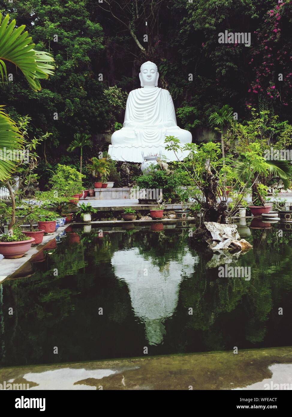 White Buddha Statue By Pond Stock Photo Alamy