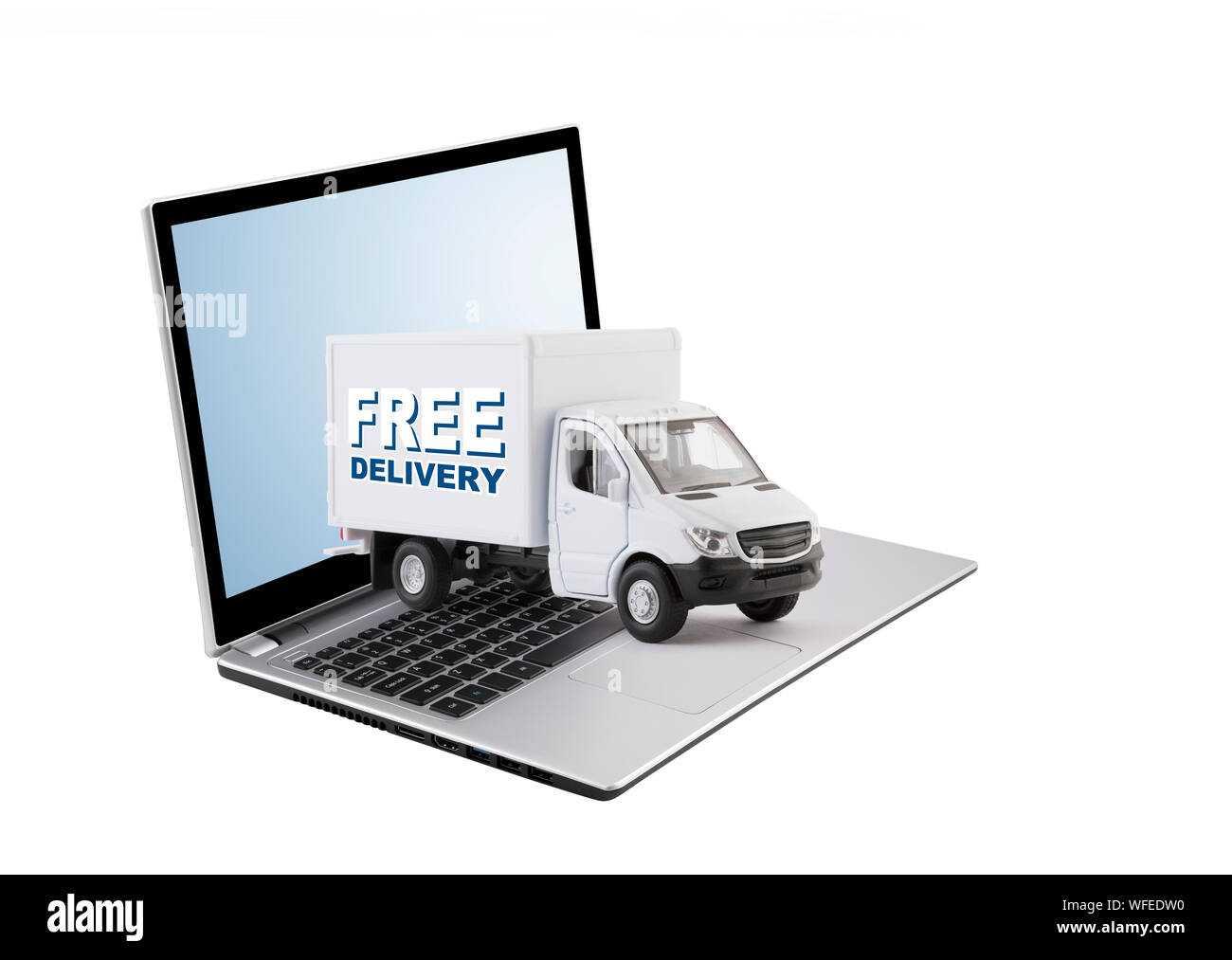 Free delivery cargo truck on laptop isolated on white background Stock Photo